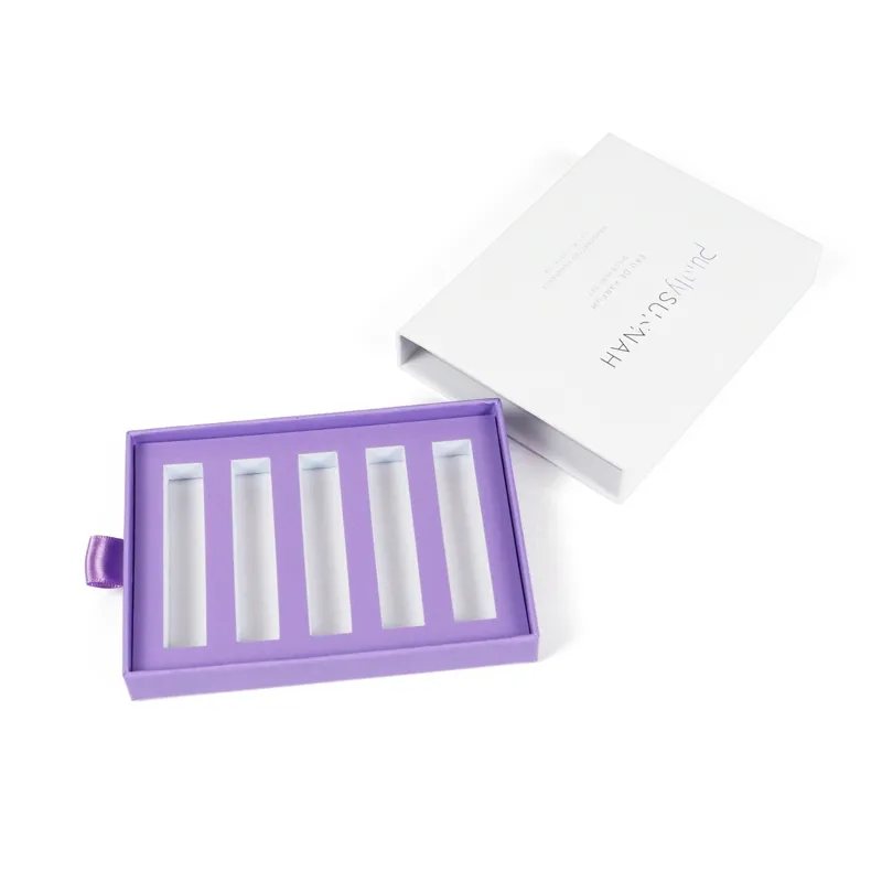Angled close-up of closed slide drawer box, highlight matching lavender satin ribbon pull tab detail on rigid perfume packaging drawer box