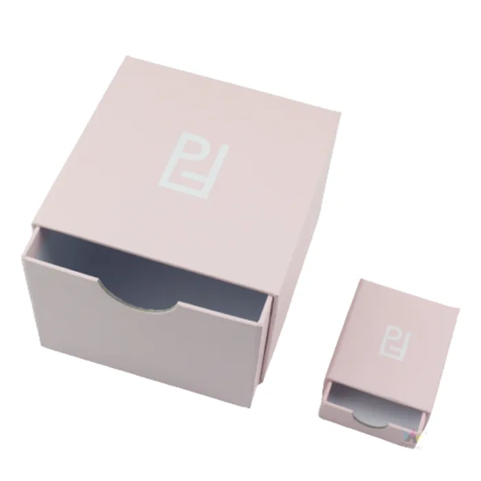 Large and small sized matte pink slide sleeve essential oil boxes with partially pulled open drawer showing empty interior