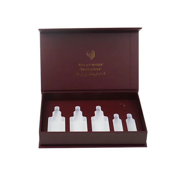 Close-up detail of gold foil emblem and multi-lingual text printed on the inner flip lid of burgundy skincare packaging