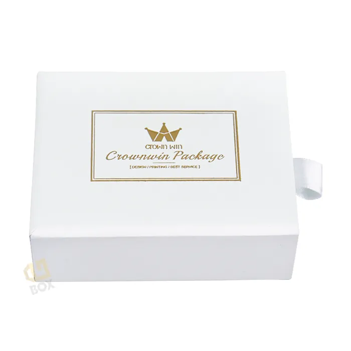 Closed front matte white rigid drawer box with elegant gold foil crown and script logo printed on top lid, small ring drawer box