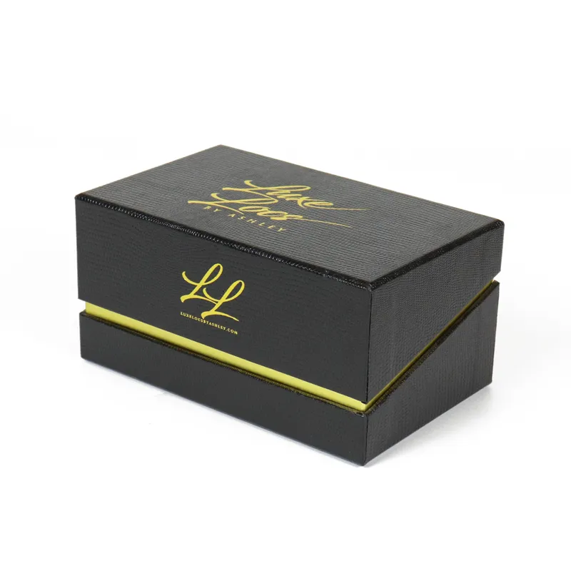 Closed embossed black lizard grain magnetic closure boxes with reflective gold foil script logo and monogram print, rigid luxury cosmetic gift packaging