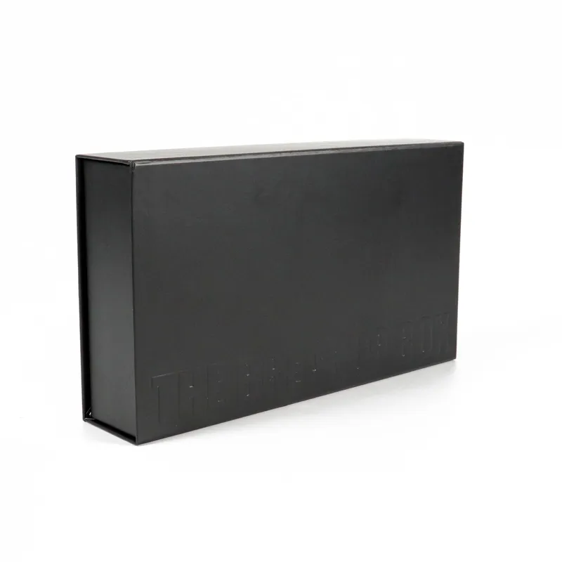 Closed matte black magnetic flip rigid cosmetic boxes with subtle blind emboss debossed brand logo on top lid