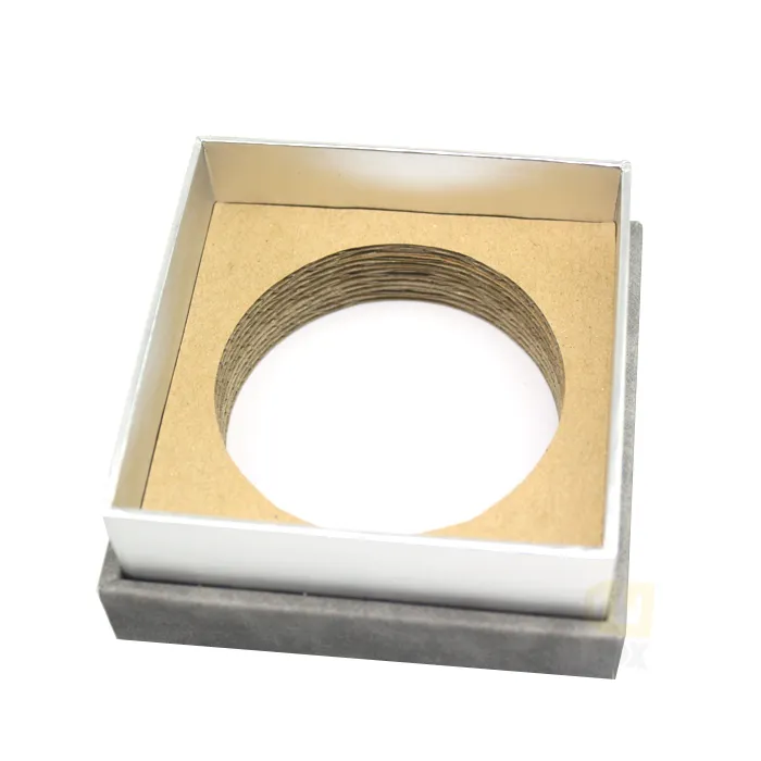 Closed square neutral grey suede candle boxes front view, subtle blind debossed framed crown brand logo on matte textured lid surface