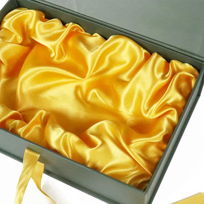 Macro close-up of intricate gold hot foil logo printed on matte green magnetic rigid box surface
