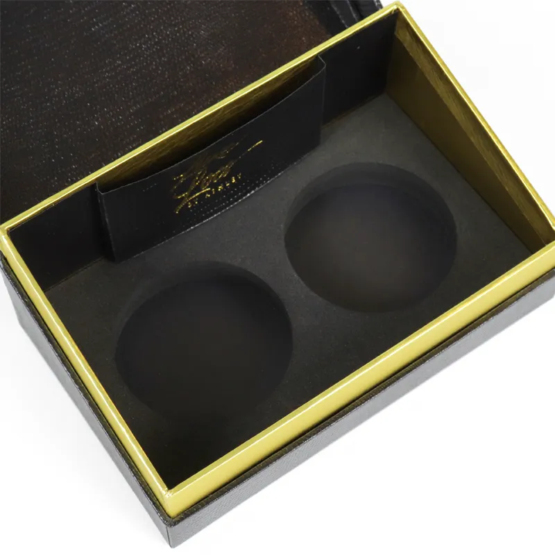 Extreme close-up of glossy gold hot foil script logo embossed on textured lizard grain surface of magnetic closure boxes