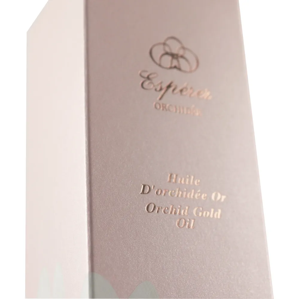 Close-up detail of rose gold foil embossed logo on soft pink floral tuck folding cartons for orchid gold skincare oil bottles