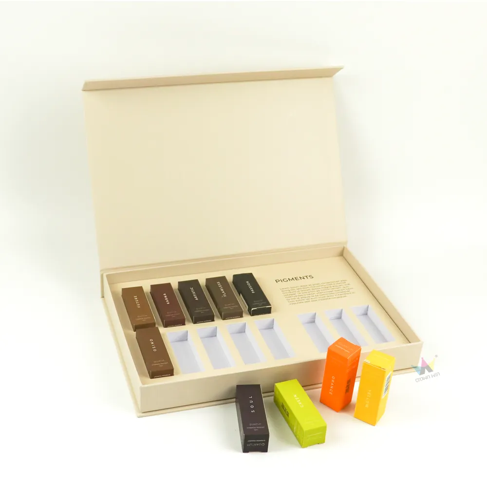 Minimalist cosmetic boxes with several pigment tubes taken out from paper divider slots, rigid beauty set packaging