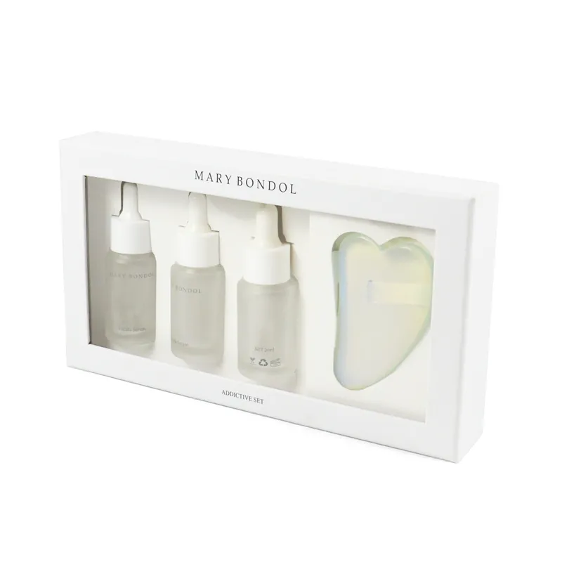 Front view window box packaging displaying serum dropper bottles and gua sha tool through clear PVC window