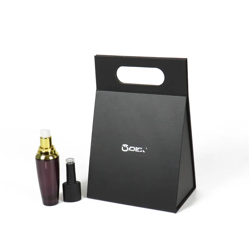 Fully assembled upright triangle folding box placed beside purple gold cosmetic serum bottle, matte black handheld triangle folding gift box for beauty products
