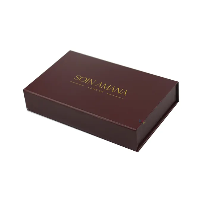 Fully opened burgundy rigid skincare packaging showing gold foil logo and multilingual slogan printed on inner green lid lining