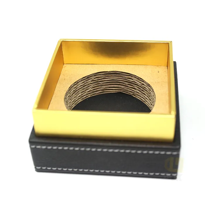Macro interior shot of glossy gold metallic inner tray fitted with pre-cut kraft corrugated circular ring liner for tall glass candle jars inside candle boxes
