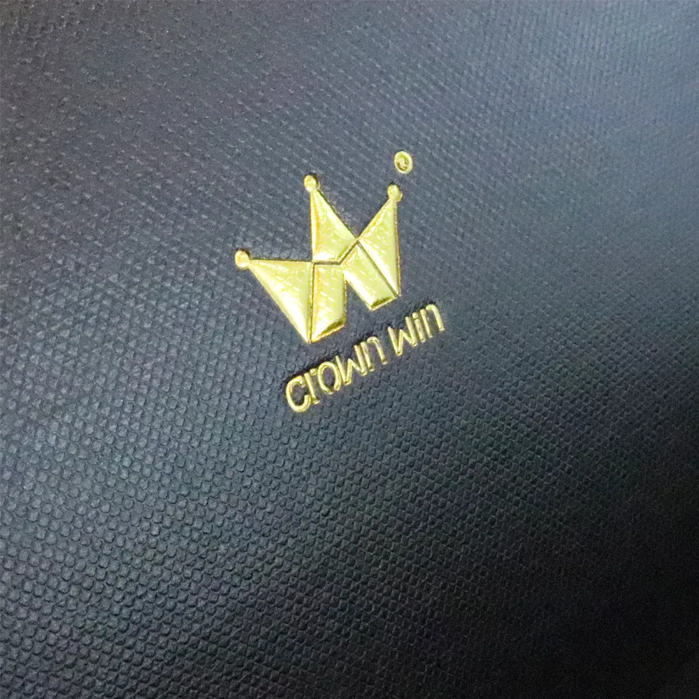 Macro close up of shiny raised gold hot foil crown brand logo printed inside the lid of black magnetic essential oil boxes