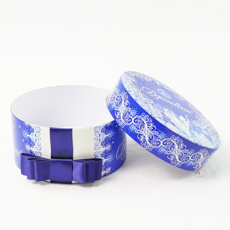 Opened blue festive cylinder boxes with purple satin bow, clean white inner paper tube