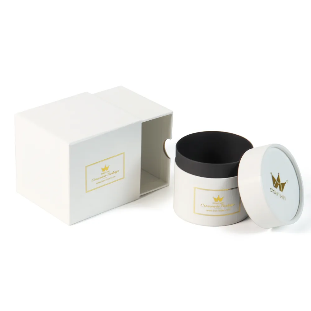 Round candle tube with lid removed showing black protective inner lining, paired with empty white drawer candle boxes