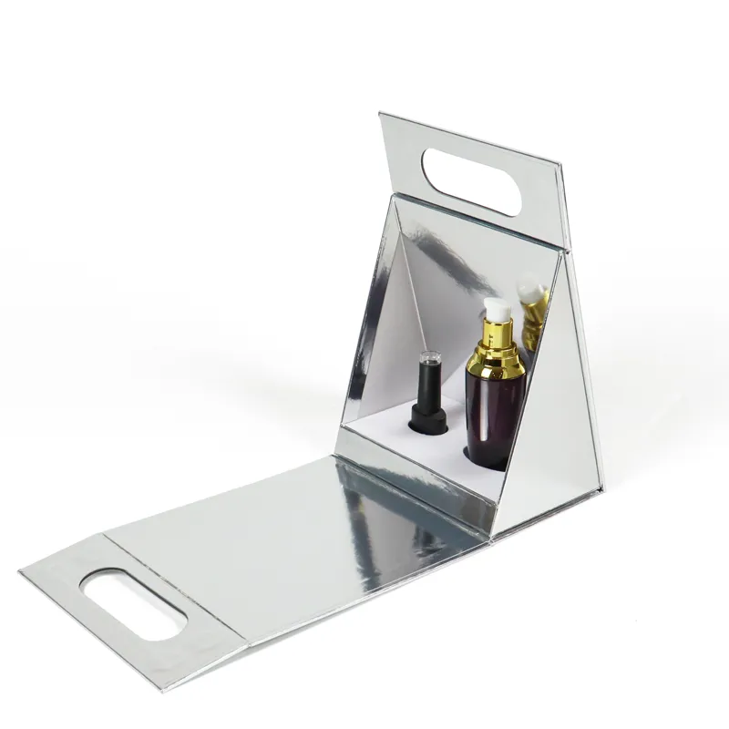 Open mirror silver metallic triangle folding box with white foam insert holding serum bottles, self-standing triangular cosmetic gift packaging with cutout handle