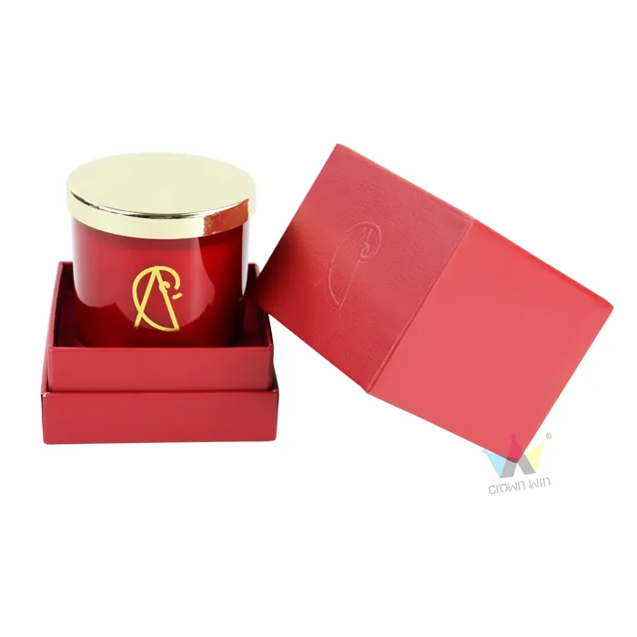 Open red leather grain rigid candle boxes with lid tilted aside, red glass scented candle jar placed inside matching red paper holding tray
