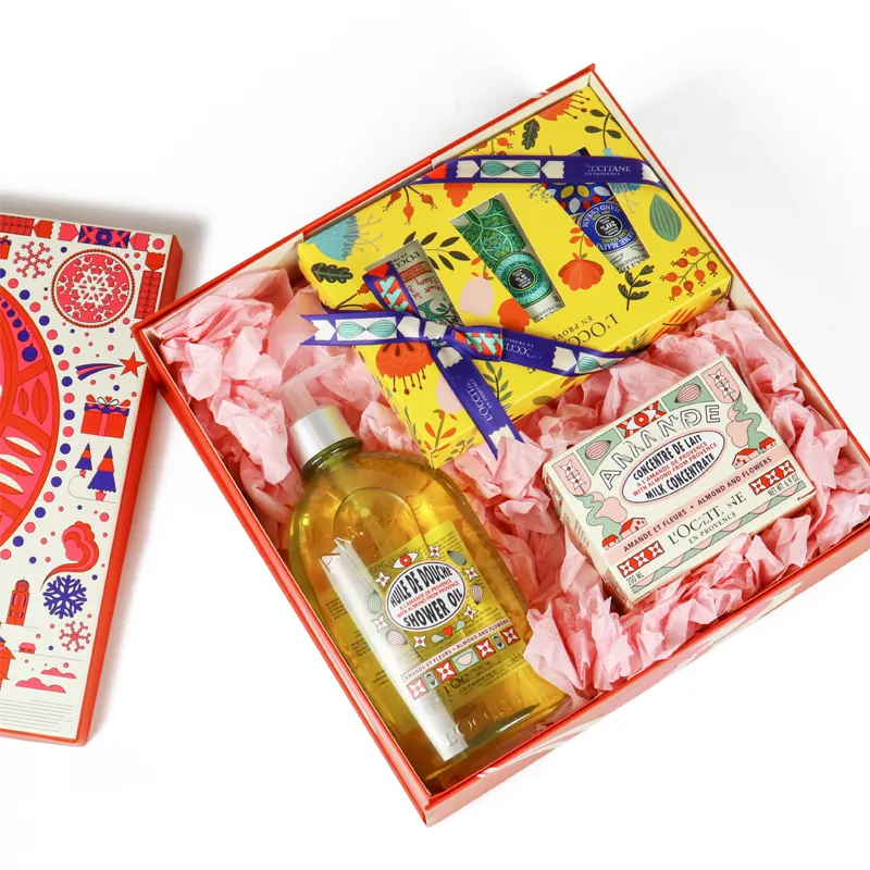 Top-down overhead view of empty flip lid skincare gift packaging lined with decorative pink shredded tissue paper