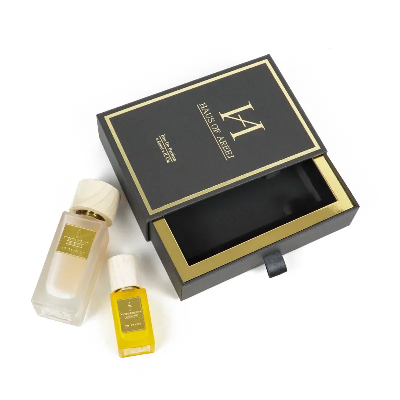Overhead top flat view of matte black slide drawer perfume boxes with shiny gold foil border and embossed brand logo on lid