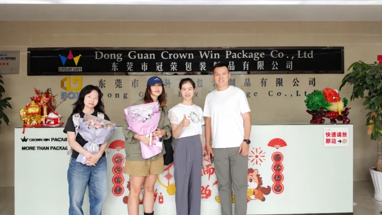 Overseas client group photo after factory inspection at Crown Win Dongguan custom paper packaging box manufacturer reception desk