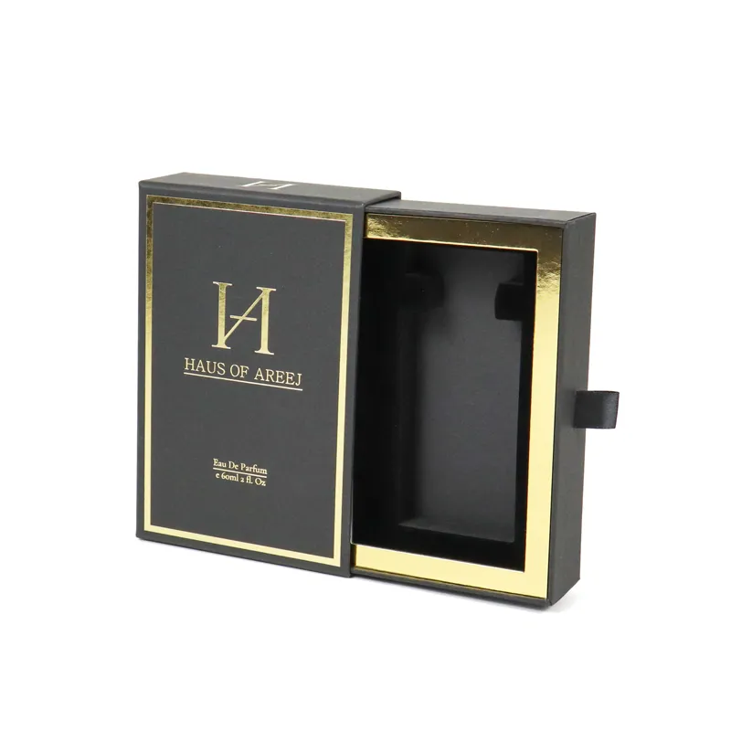 Side profile partial open shot of black gold perfume boxes highlighting delicate black satin ribbon pull tab on slide drawer edge