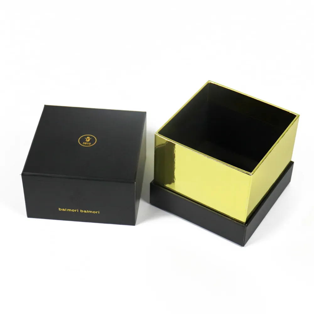 Three-quarter angle shot of open square black essential oil boxes revealing reflective metallic gold inner sleeve lining
