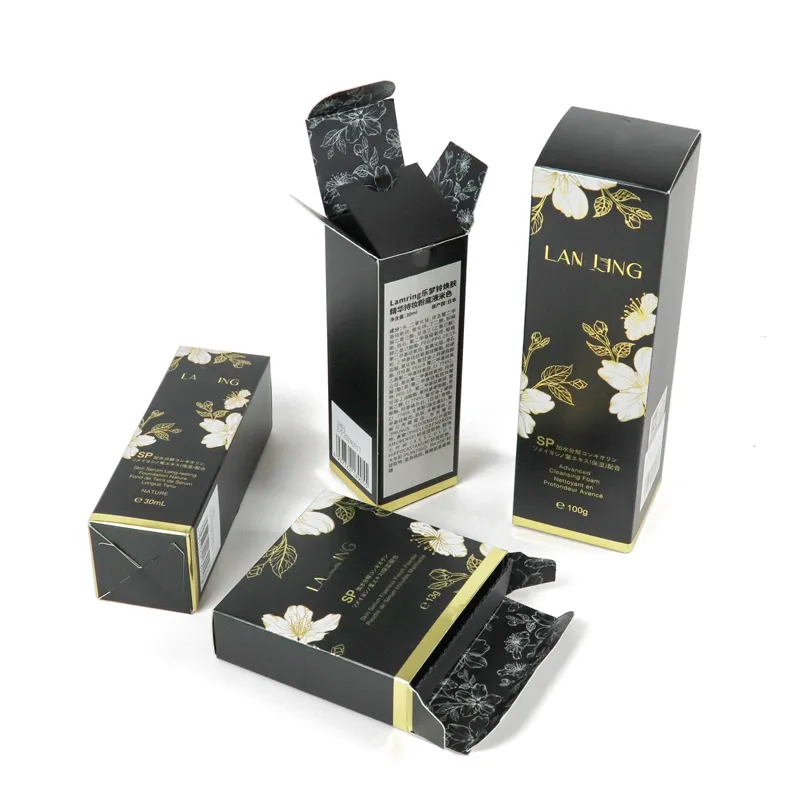 Front standing shot of three different sizes black matte gold foil floral tuck folding cartons for skincare makeup bottles