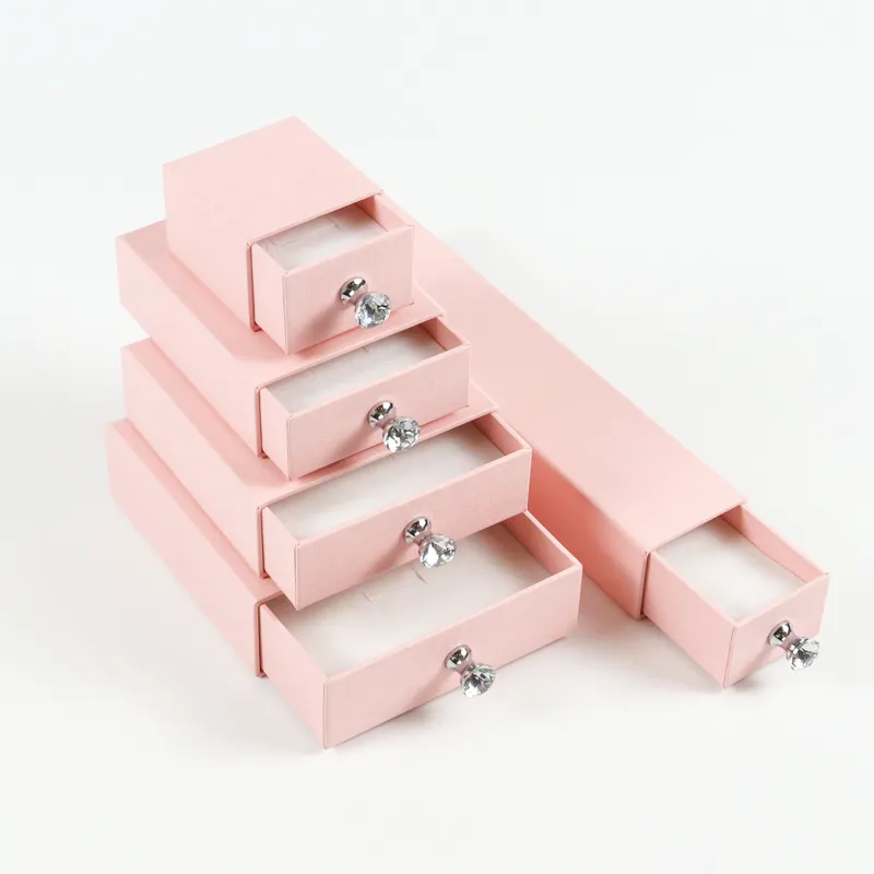 Tiered stacked display of slide-out linen drawer box, shiny crystal pull knob detail on pastel pink jewelry drawer box set