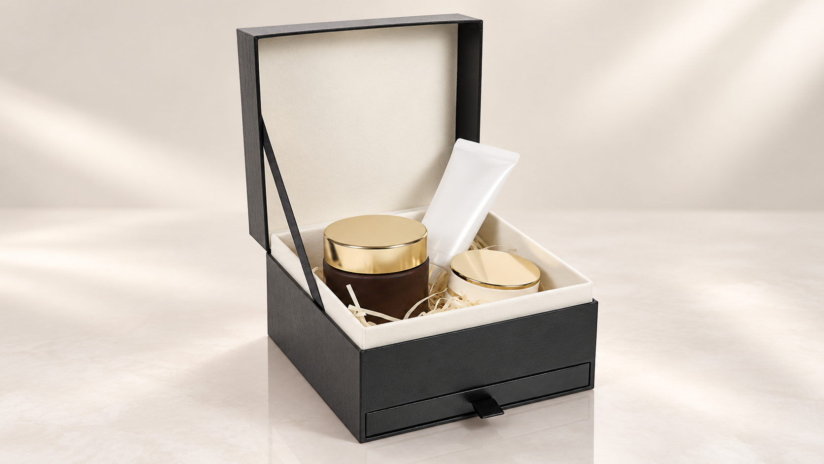 Open black cosmetic gift box with skincare products, centered on a warm ivory studio background